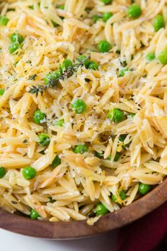 a wooden bowl filled with pasta and peas