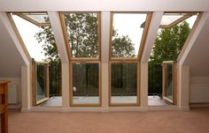 an empty room with large windows and sliding glass doors on the outside, looking out onto trees