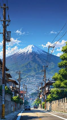 a car driving down a street in front of a tall snow covered mountain with power lines above it