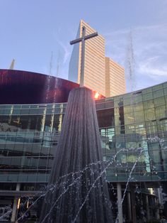 a water fountain in front of a large building with a cross on it's top