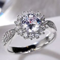 a diamond ring is shown on a white surface with diamonds around the band and center stone