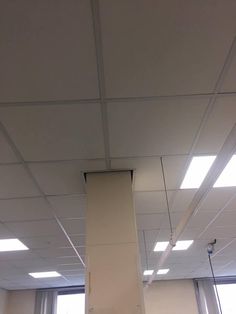 the ceiling in an office building has been painted white and is being worked on by workers