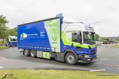 a blue and green truck driving down the road