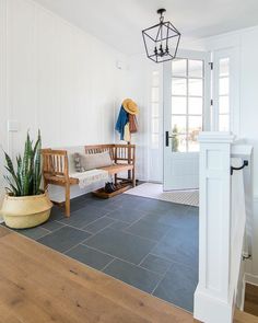 a living room with white walls and wood furniture