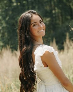 a beautiful young woman standing in a field