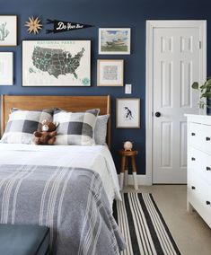 a bed room with a neatly made bed and pictures on the wall