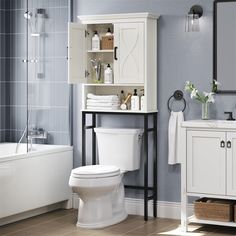 a white toilet sitting next to a bath tub in a bathroom under a sink mirror