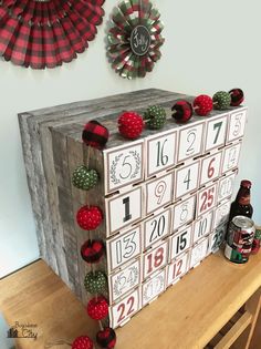 a wooden calendar with red and green decorations on it sitting on top of a table