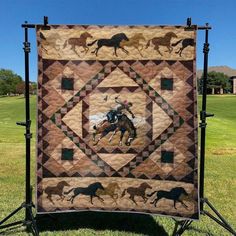 a quilt with horses on it in the grass