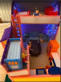 a toy house made out of legos with kids playing in the living room and bedroom