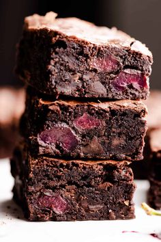 four brownies stacked on top of each other with cherries in the middle and one piece cut off