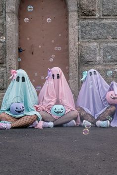 three ghost dolls sitting on the ground in front of a door with soap bubbles floating around them