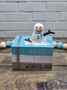 a snowman sitting on top of a book with the title walking in a winter wonderland