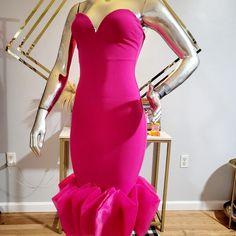 a mannequin dressed in a pink dress with ruffles on the bottom