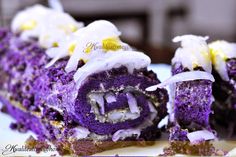 purple cake roll with white icing and coconut on the top, cut in half