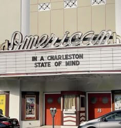 an old movie theater with cars parked in front