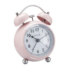 a pink alarm clock sitting on top of a table