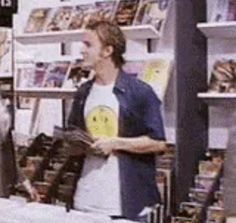 a man standing in front of a store counter holding a glove and looking at the camera