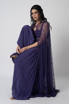 Purple semi sheer long cape with embroidered work. Comes with padded, embroidered blouse and flared pant.
Components: 3
Pattern: Hand Embroidered
Neckline: Blouse: Straight Notched
Sleeve Type: Blouse: Sleeveless
Fabric: Crepe
Color: Purple
Other Details: 
Attached lining
Length:
Cape: 56 inches
Pant: 42 inches
Model height: 5ft 8inches, wearing size S
Occasion: Destination Wedding - Aza Fashions Hand Embroidered Blouse, Long Cape, Blouse Sleeveless, Embroidered Neckline, Pant Set, Embroidered Blouse, Set For Women, Aza Fashion, Fashion Set