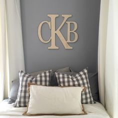 the monogrammed letter k is mounted on the wall above the bed