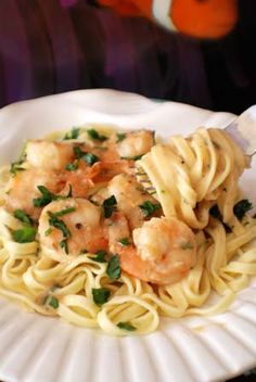 pasta with shrimp and parsley on a white plate