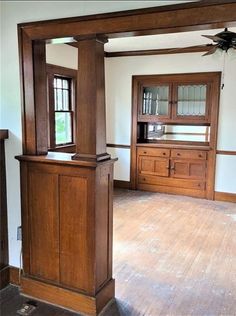 an empty room with wooden furniture and windows