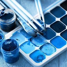 some paint and brushes sitting on top of a table