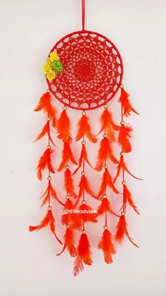 a red dream catcher hanging on a wall