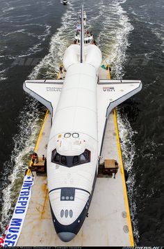 the space shuttle is being towed by a boat