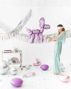 a woman standing in front of balloons and decorations