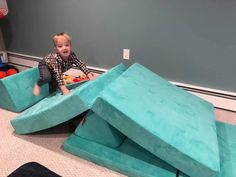 a young boy sitting on top of a blue couch