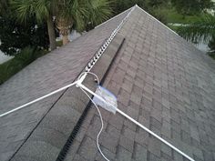 an antenna on top of a roof with palm trees in the background