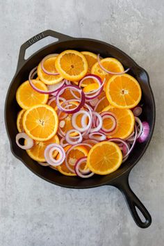 onions, oranges and onions are being cooked in a skillet on the table