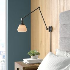 a bedroom with a bed and a lamp on the wall next to it's headboard