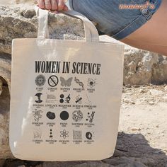 a woman is holding a bag that says women in science