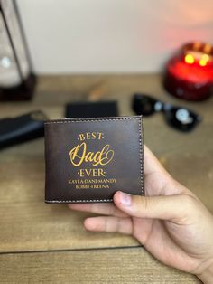 "Best Dad Ever Leather Wallet With Children Names, Father's Day Gift, Custom Leather Engraved Wallet, Wallet For Men, Personalized Gift ✦Do you need a high-quality, protective wallet that will hold your valuables in a secure and stylish way? You have come to the right place! ✦Our wallets are made from the finest vegetable-tanned full-grain leather. The perks of having the wallet made from premium quality full-grain leather makes the wallet age backward; the color becomes more vibrant and pretty. ✦Alongside its durability, our wallets are built-in with RFID blocking to protect your identity so that it doesn't go into the wrong hands. ✦Add a personal touch to this wonderful wallet by engraving and adding a quote to the side of your choice! ✦This wallet is a perfect present for Your Loved One Brown Wallets For Father's Day, Brown Wallet For Father's Day, Father's Day Gift Wallets With Coin Pocket, Father's Day Wallets With Coin Pocket, Father's Day Gift Wallet With Coin Pocket, Customizable Wallets For Everyday Use, Father's Day Rectangular Wallets With Card Slots, Personalized Bifold Wallet For Father's Day, Bifold Wallet For Father's Day