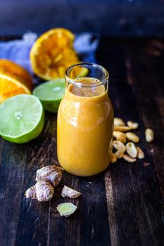 a glass jar filled with orange juice next to sliced lemons