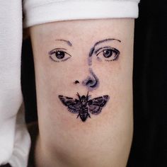 a woman's face with a butterfly on her cheek