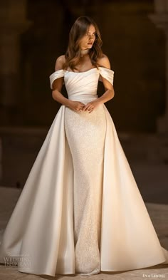 a woman in a white dress posing for the camera with her hands on her hips