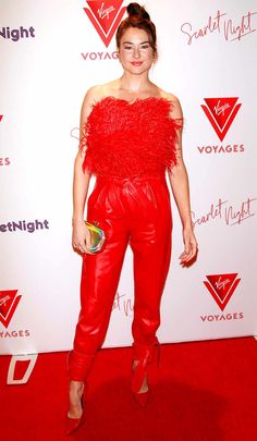 a woman in red is standing on a red carpet