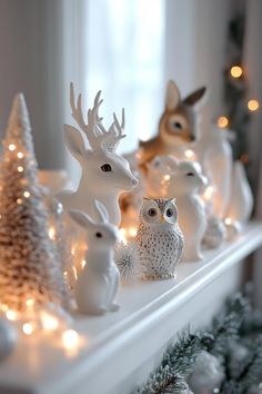 christmas decorations on a mantle with lights and deer figurines