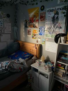 a bed room with a neatly made bed and posters on the wall