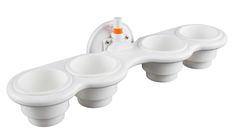 three white cups are in the shape of a toothbrush holder with an orange top