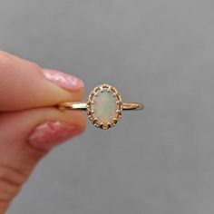 This antique style crown ring comes with a gorgeous Australian oval opal. If you want a different stone or want to add accent diamonds contact us for a quote. Details: - Default stone size is 7x5mm Australian Opal in oval shape. - Shiny finish by default. - Default width is 1.8mm at the bottom and 8.7x6.5mm at the top - Default thickness is 1.6mm at the bottom and 2mm at the top. - Contact us for quote if you want to customize this ring in any way. Thank you for shopping with Sevgi Jewelry! Oval Opal Halo Ring In 14k Gold, Heirloom 14k Gold Opal Ring Oval Cabochon, Delicate Gold Oval Opal Ring, 14k Gold Oval Cabochon Opal Ring For Anniversary, Classic 14k Gold Opal Ring With Halo, 14k Gold Opal Ring With Halo Setting, Classic Oval Opal Ring With Halo, Oval Opal Ring With Halo Setting In 14k Gold, Heirloom Oval Opal Ring With Halo Setting