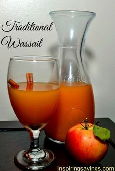 there is an apple next to a pitcher and glass with liquid in it on the table