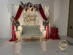 a white couch sitting in front of a red and white wall with flowers on it