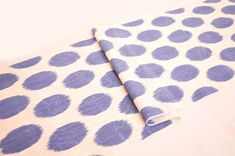 a roll of blue and white polka dot fabric sitting on top of a tablecloth