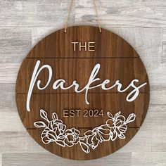 a wooden sign that says the parkers est 2024 with flowers and leaves on it