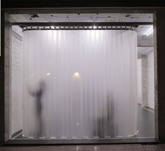 a person standing in front of a white curtain