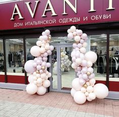 two large balloons are in front of a clothing store with the words avani on it